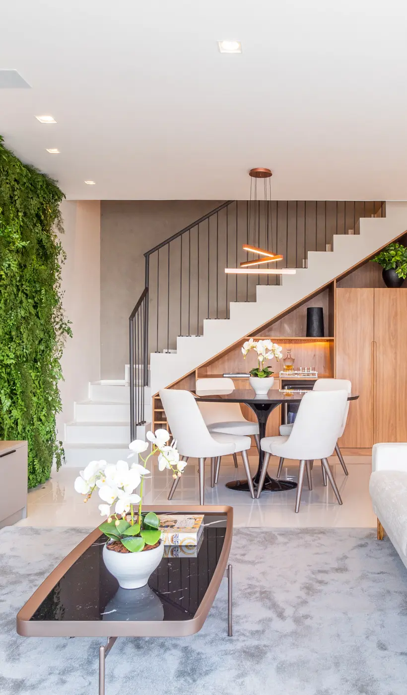 Sala de um apartamento sob gestão HostnJoy: jardim vertical, mesa de jantar e escada